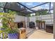 Outdoor kitchen area features a grill, patio with an overhead shelter, and lush plants for a relaxing culinary experience at 6407 E 112Th Ave, Temple Terrace, FL 33617