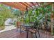 Cozy outdoor seating area under a pergola, surrounded by lush tropical plants and a stone-paved walkway at 6407 E 112Th Ave, Temple Terrace, FL 33617