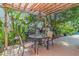 Charming outdoor seating on a wooden deck under a pergola, surrounded by lush, vibrant greenery for a serene retreat at 6407 E 112Th Ave, Temple Terrace, FL 33617