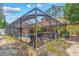 Screened pool area with lush landscaping, providing a private outdoor retreat with a covered patio and ample seating at 6407 E 112Th Ave, Temple Terrace, FL 33617