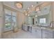 Elegant bathroom with dual vanities, a freestanding tub, and decorative light fixtures at 715 Pinckney Dr, Apollo Beach, FL 33572