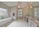 Bright bathroom featuring dual vanities, a freestanding tub, and marble flooring at 715 Pinckney Dr, Apollo Beach, FL 33572