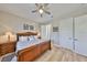 Serene bedroom features wood floors, warm lighting, and an adjacent bathroom for privacy and convenience at 715 Pinckney Dr, Apollo Beach, FL 33572