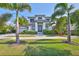 Stunning two-story home with lush lawn, elegant landscaping, and a stately entrance framed by swaying palm trees at 715 Pinckney Dr, Apollo Beach, FL 33572