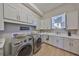 Bright laundry room with built-in cabinets, countertops, and stainless steel appliances at 715 Pinckney Dr, Apollo Beach, FL 33572