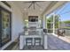 Well-equipped outdoor kitchen featuring granite countertops, a built-in grill, bar seating, and a TV for entertaining at 715 Pinckney Dr, Apollo Beach, FL 33572