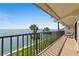 Relax on the tiled balcony with metal railings and a seating area, overlooking the lush lawn and ocean view at 7540 Sunshine Skyway S Ln # 219, St Petersburg, FL 33711