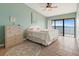 Light bedroom with water view balcony, ceiling fan, and shell-themed dresser at 7540 Sunshine Skyway S Ln # 219, St Petersburg, FL 33711