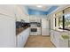 Charming kitchen with white cabinets, stainless steel appliances, blue backsplash, and breakfast nook at 7540 Sunshine Skyway S Ln # 219, St Petersburg, FL 33711