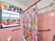 Bright bathroom featuring pink tile and colorful shower curtain and window dressings at 8014 N Lynn Ave, Tampa, FL 33604