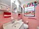 Cozy bathroom with colorful decor, pink tiling, and vintage fixtures and cabinetry at 8014 N Lynn Ave, Tampa, FL 33604