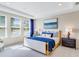 Bright bedroom featuring large windows, a cozy bed with blue accents, and a decorative wall art piece at 841 Steel Dr, Apollo Beach, FL 33572