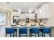 Featuring a large quartz counter with seating, pendant lights, stainless appliances, and white cabinets at 841 Steel Dr, Apollo Beach, FL 33572