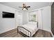 A well lit bedroom featuring a black metal bed frame, wood-style floors, and white curtains at 847 Highland N St, St Petersburg, FL 33701