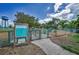 Entrance to a fenced dog park, featuring guidelines signage, lush greenery, and a clear sky, perfect for pet owners at 847 Highland N St, St Petersburg, FL 33701