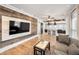 Modern living room featuring wood accent wall, open to kitchen with wood floors and neutral tones at 847 Highland N St, St Petersburg, FL 33701