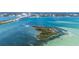 Breathtaking aerial view of a small island, featuring clear turquoise waters, and lush greenery at 855 Bayway Blvd # 703, Clearwater Beach, FL 33767