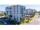 Beautiful condo building with large windows, mature landscaping, and ample parking for residents and guests at 855 Bayway Blvd # 703, Clearwater Beach, FL 33767
