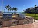 Outdoor grilling area with two stainless steel gas grills with waterfront views and palm trees at 855 Bayway Blvd # 703, Clearwater Beach, FL 33767