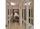 Bright hallway featuring tiled floors and mirrored closet doors leading to a bedroom at 855 Bayway Blvd # 703, Clearwater Beach, FL 33767