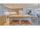 Well-lit kitchen with stone countertops, white cabinets, a microwave, and a dining area with seating at 855 Bayway Blvd # 703, Clearwater Beach, FL 33767