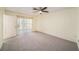 Spacious bedroom with a ceiling fan and sliding glass doors leading to a sunroom at 9413 Stonewall Ln, New Port Richey, FL 34655