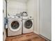 Efficient laundry room with modern white appliances and overhead shelving at 10409 Fly Fishing St, Riverview, FL 33569