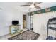 Exercise room with ceiling fan, a treadmill, sliding glass doors, television, and a decorative rug on the tile floor at 10737 Scenic Dr, Port Richey, FL 34668