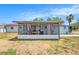 A screened lanai, perfect for enjoying the outdoors, is attached to the light blue single Gathering home at 10737 Scenic Dr, Port Richey, FL 34668