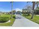 A single-Gathering home with a long driveway, palm trees, and a well-maintained lawn at 10737 Scenic Dr, Port Richey, FL 34668