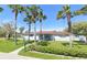 Charming single-story home with a lush green lawn and mature palm trees creating a tropical feel at 10737 Scenic Dr, Port Richey, FL 34668
