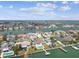 Aerial view showcases a waterfront community with single-Gathering homes, canals, and a bay in the background at 11340 5Th E St, Treasure Island, FL 33706