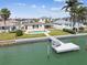 View of a backyard featuring a private dock, in-ground pool, and well-maintained landscaping, perfect for outdoor enjoyment at 11340 5Th E St, Treasure Island, FL 33706
