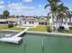 Backyard showcasing a refreshing in-ground pool, a private dock, and lush landscaping near the waterfront at 11340 5Th E St, Treasure Island, FL 33706