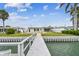 Backyard view from the dock featuring a lush lawn, waterfront access, and a pathway to the home at 11340 5Th E St, Treasure Island, FL 33706