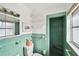 Bright, quaint vintage-style bathroom featuring green tile and classic fixtures at 11340 5Th E St, Treasure Island, FL 33706