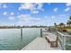 White wooden dock featuring a built-in bench, creating a serene waterfront experience with blue skies at 11340 5Th E St, Treasure Island, FL 33706