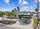 Exterior view of waterfront home with a paver driveway, palm trees and RV parking at 11340 5Th E St, Treasure Island, FL 33706