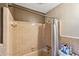 Close up of tan and white tiled shower with fixtures and shower curtain at 11340 5Th E St, Treasure Island, FL 33706