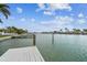 Beautiful waterfront view with docks, palm trees, and calm waters under a blue sky with clouds at 11340 5Th E St, Treasure Island, FL 33706
