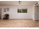 An airy living room features a neutral color palette, floating shelves and brown tile floors at 11708 Raintree Village Blvd # A, Temple Terrace, FL 33617