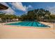 Large community pool with clear blue water and lots of chairs at 11708 Raintree Village Blvd # A, Temple Terrace, FL 33617