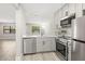Charming kitchen featuring stainless steel appliances, sleek countertops, and gray cabinets at 13250 Ridge Rd # 4B3, Largo, FL 33778