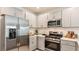 Modern kitchen featuring stainless steel appliances, ample cabinets, and stylish countertops at 13253 Tropical Breeze Way, Hudson, FL 34669