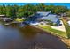 Lakefront home showcasing private dock, screened pool area, and beautifully maintained lawn and landscaping at 13548 Lake Magdalene Dr, Tampa, FL 33613