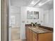 Bright bathroom with granite counters and a view into the bedroom at 13548 Lake Magdalene Dr, Tampa, FL 33613