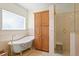Bright bathroom featuring a clawfoot tub, shower, and tile flooring at 13548 Lake Magdalene Dr, Tampa, FL 33613