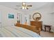 This bedroom features a ceiling fan, wooden dresser and a round mirror at 13548 Lake Magdalene Dr, Tampa, FL 33613