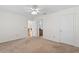 A bedroom with neutral carpet and white walls, featuring two doorways and a closet door at 13548 Lake Magdalene Dr, Tampa, FL 33613