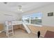 Bedroom with a bunk bed, ladder, and slide next to a large sunny window at 13548 Lake Magdalene Dr, Tampa, FL 33613